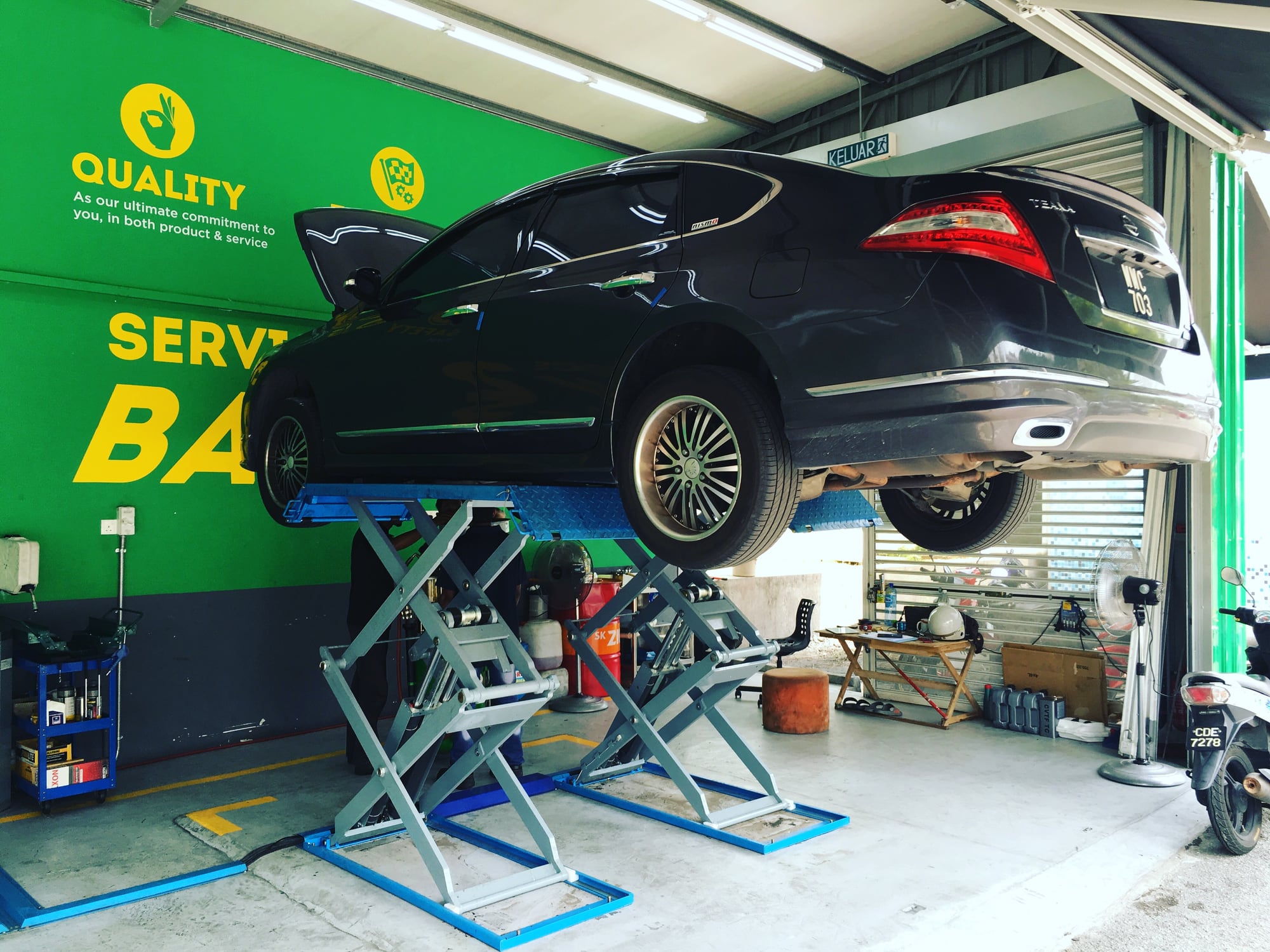 A car raised on the lift inside a DTOX service bay